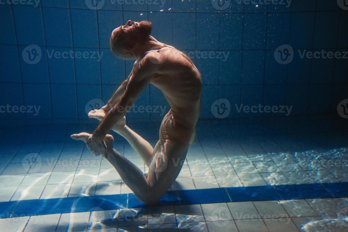 atletisch sport Mens onderwater- in de zwemmen zwembad. sport, yoga, vrij duiken concept foto