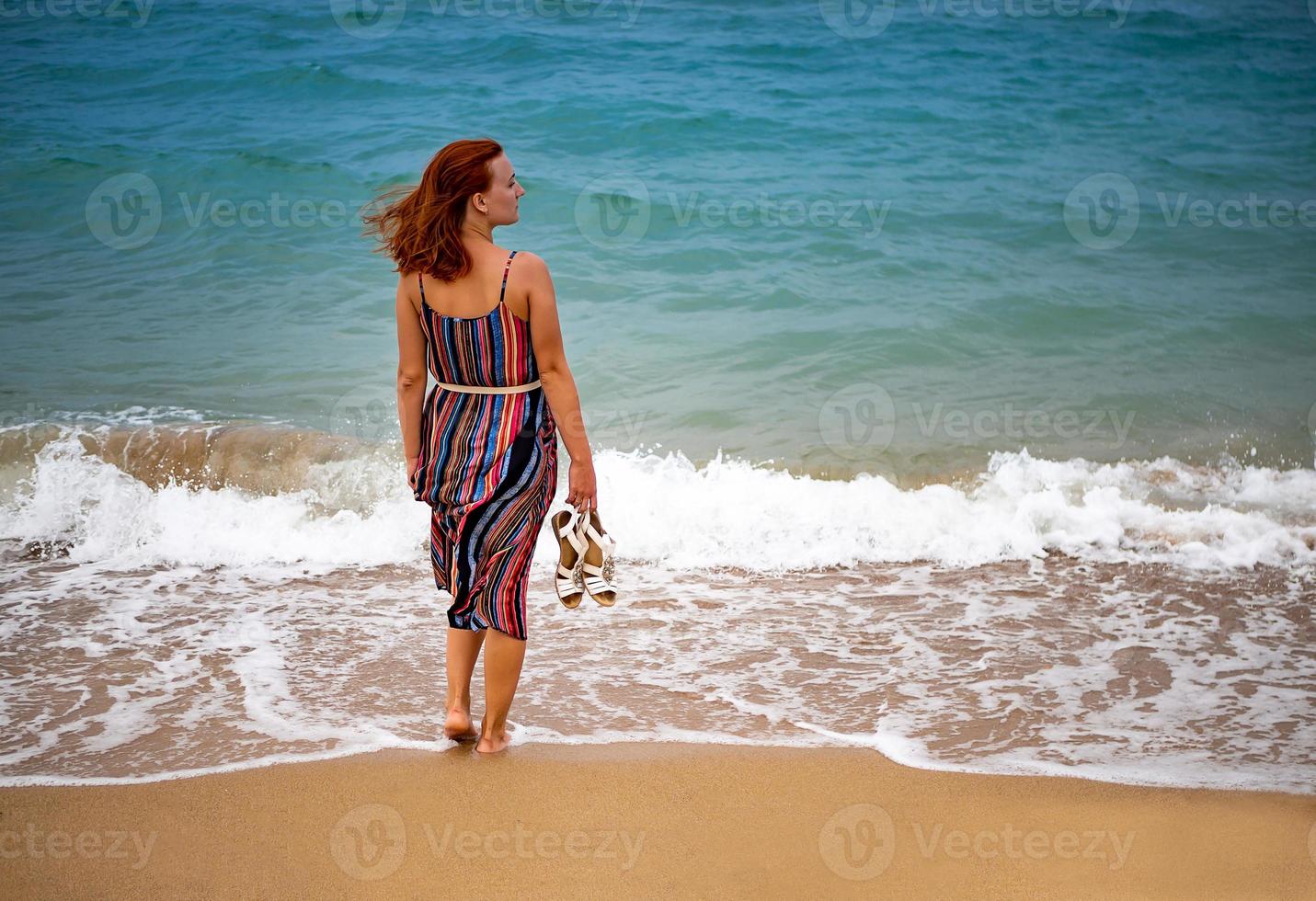 gelukkig jong boho vrouw wandelen en hebben pret in de zee golven Aan een zonnig warm dag Aan een tropisch eiland. foto