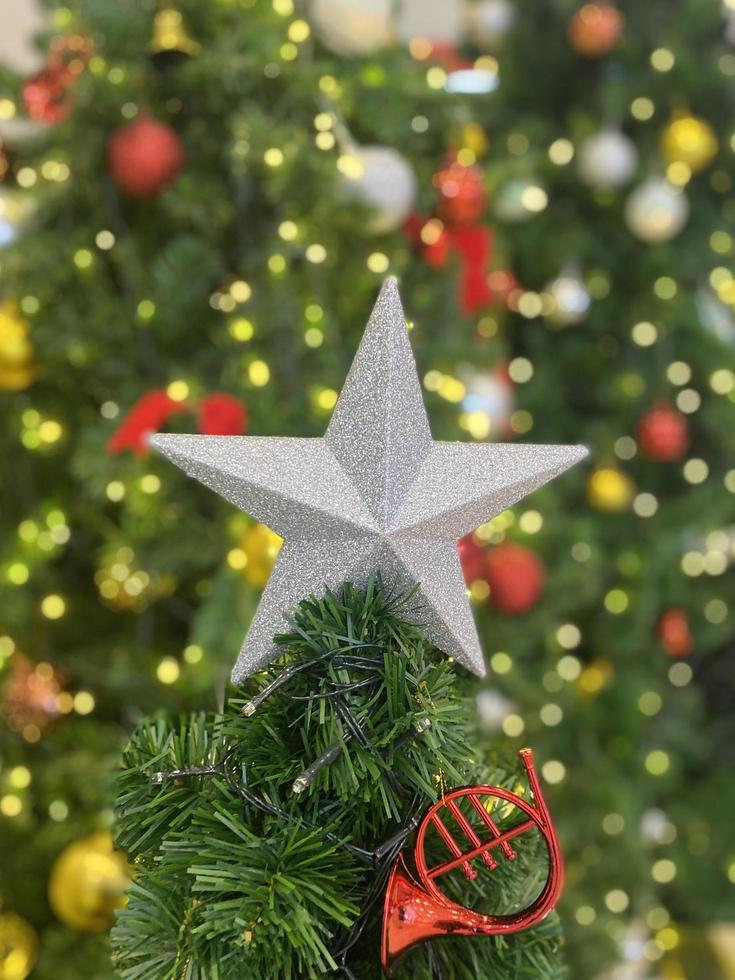 ster Kerstmis Aan boom achtergrond. gelukkig nieuw jaar en vrolijk Kerstmis 2023 viering concept foto