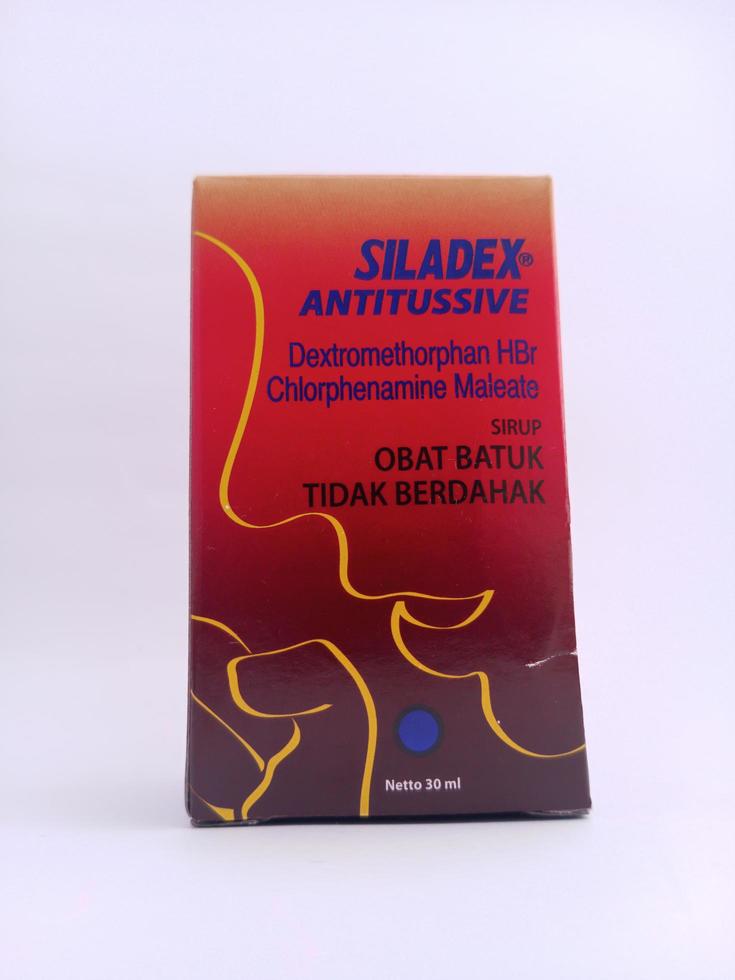 malang, Indonesië - november, 2022, hoesten siroop geneeskunde met de siladex merk. heeft een rood verpakking. met wit geïsoleerd achtergrond foto
