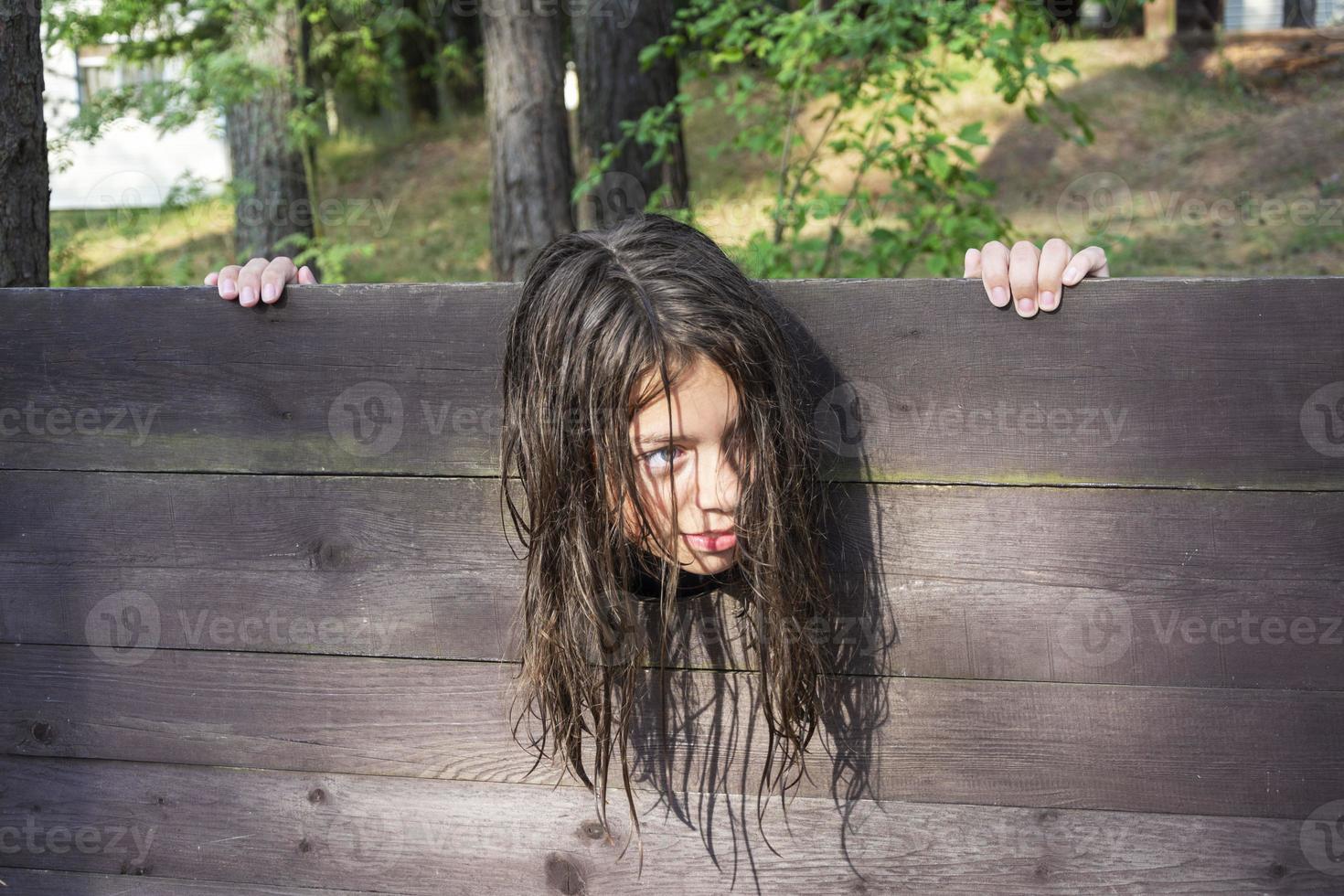 de hoofd van een meisje met lang verward haar- geklemd in een guillotine, een tafereel van een middeleeuws uitvoering, een zin foto