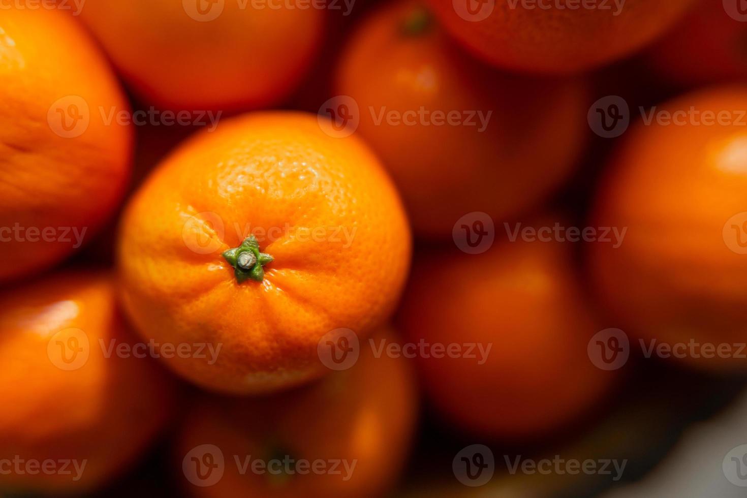 mand met mandarijn of oranje fruit Aan een grijs plaid achtergrond. foto