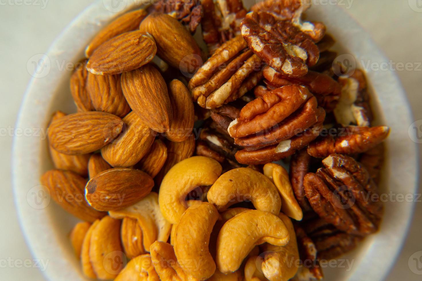 mengen walnoten, pecannoot, amandelen, cashewnoten Aan een mooi stellage, gezond noten. foto