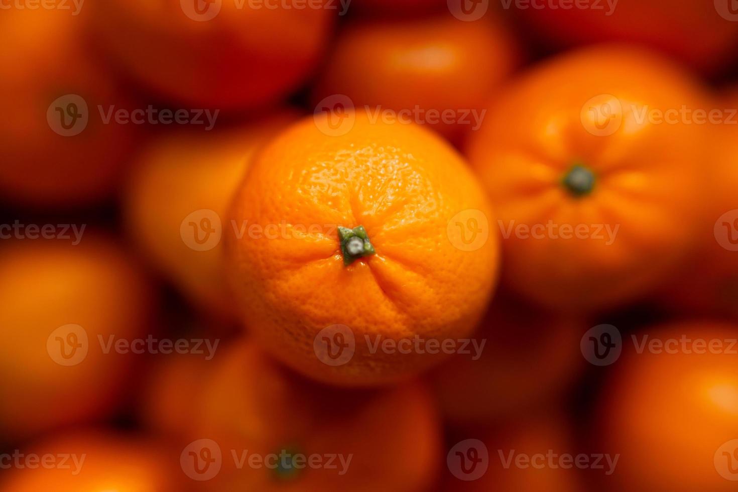 mand met mandarijn of oranje fruit Aan een grijs plaid achtergrond. foto