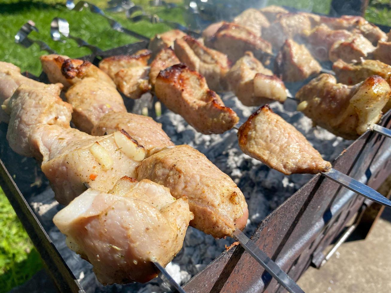 heerlijk mooi gebakken varkensvlees spiesjes Aan de rook gekookt Aan de rooster met spiesjes met kolen. barbecue in natuur. bbq foto