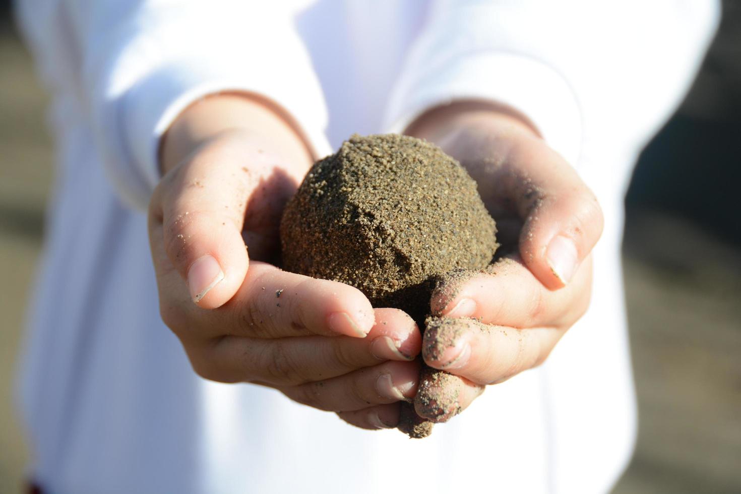 kinderen handen spelen met zand bal foto