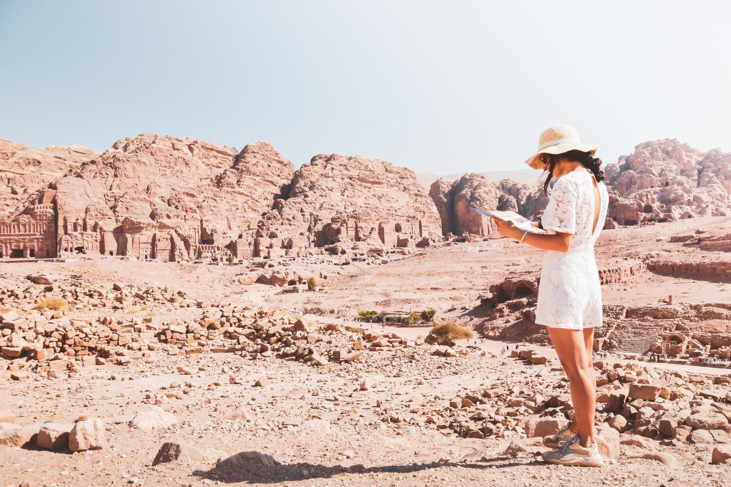 modieus Kaukasisch vrouw toerist, lezen kaart, plan verkennen de bezienswaardigheden van de oud, fantastisch stad van petra in Jordanië. kleurrijk foto's. concept van vrije tijd, vakantie en reizen foto