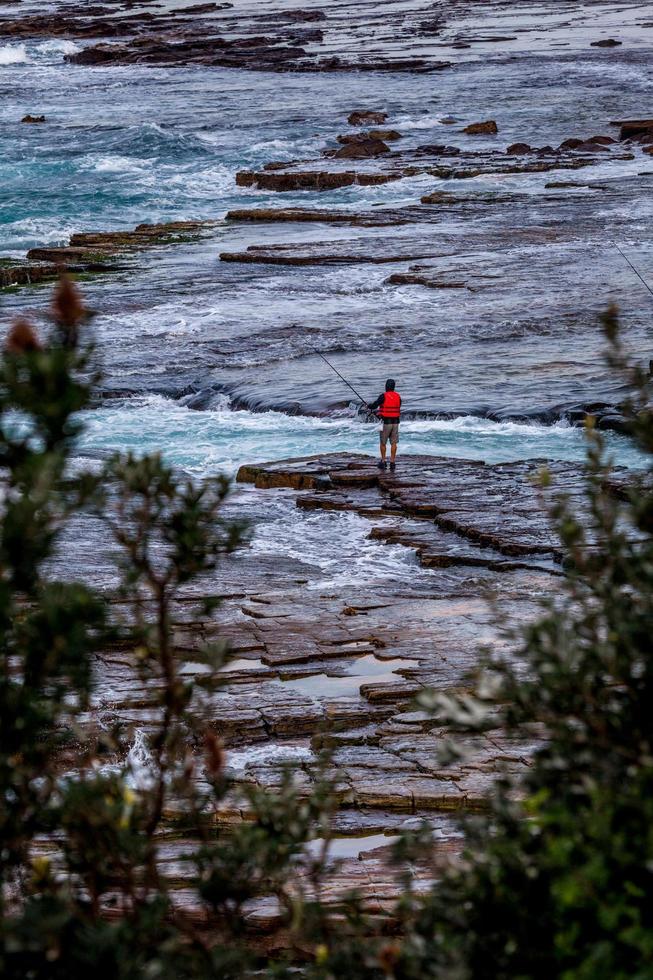 sydney, Australië, 2020 - een weergave van een persoon op een rotsachtige kust foto