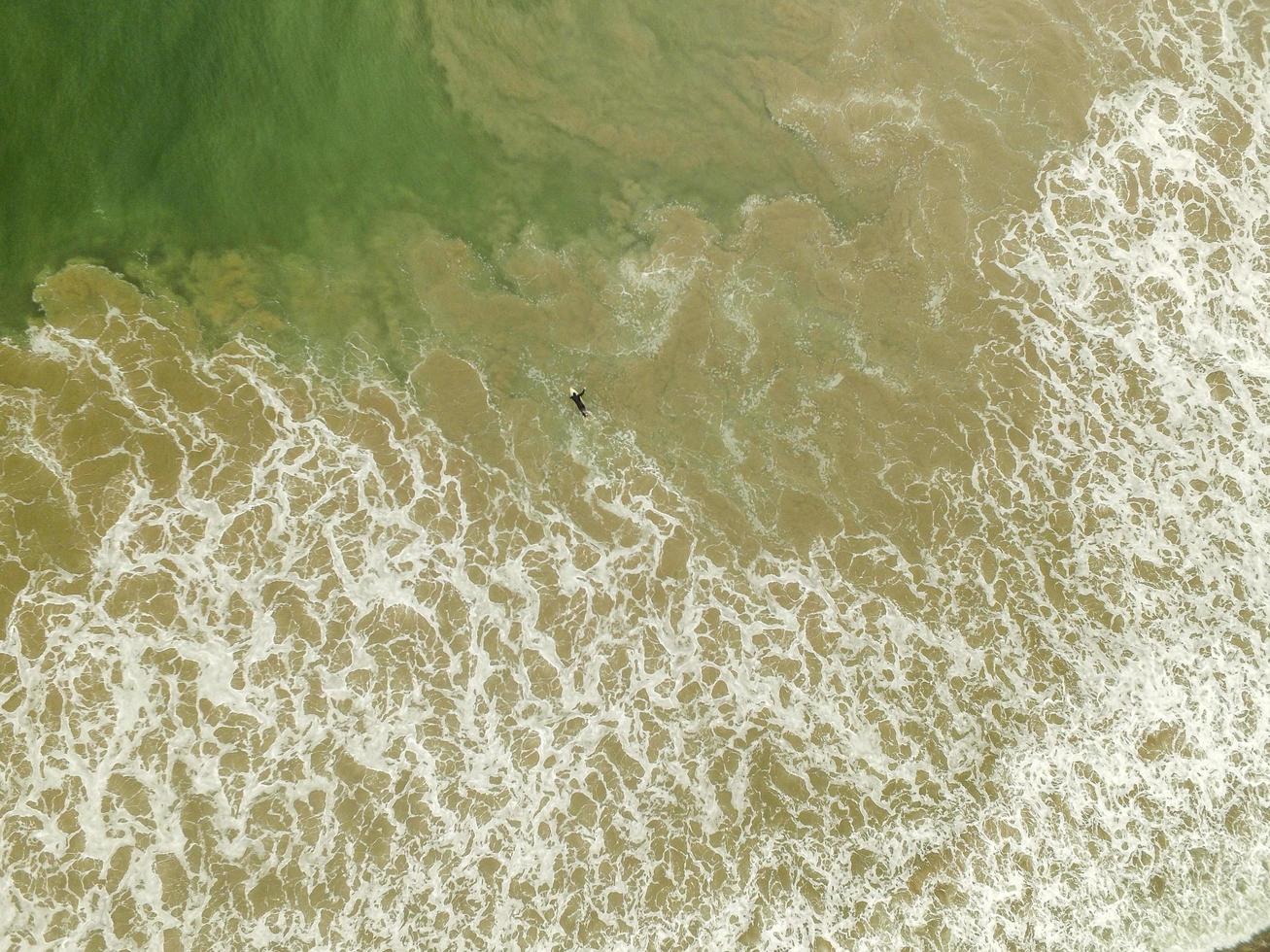 luchtfoto van solo surfer in de oceaan overdag foto
