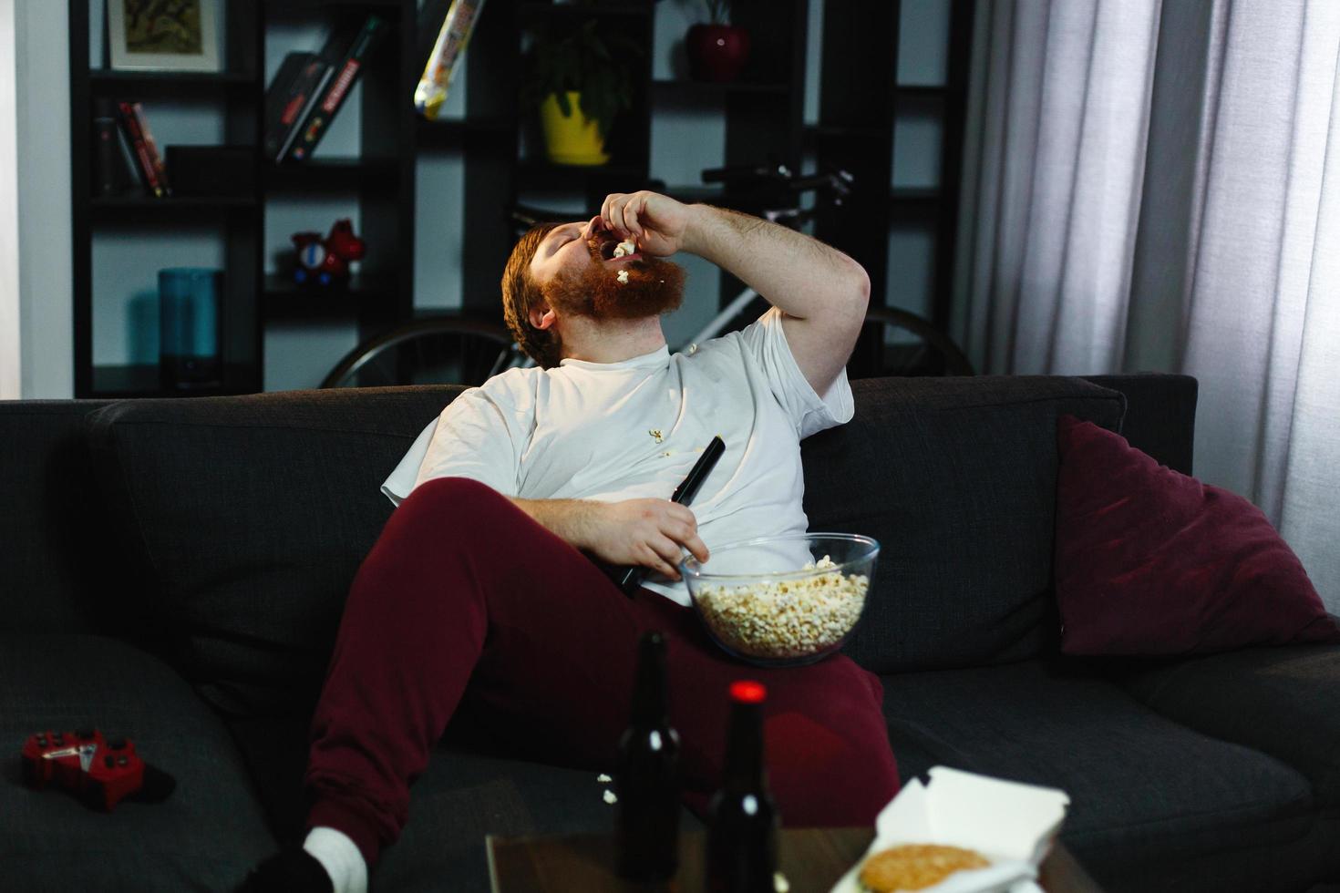 gelukkige dikke man eet popcorn foto