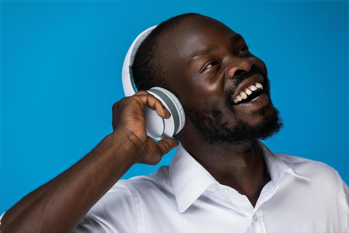 lachende Afrikaanse man geniet van het luisteren naar muziek foto