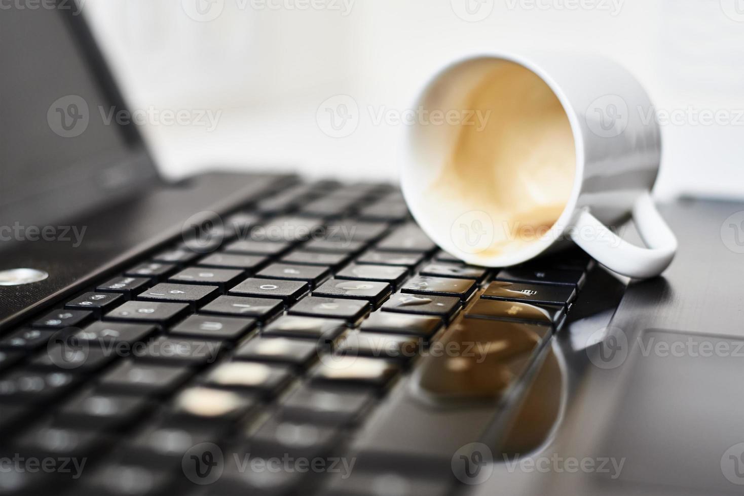 morsen koffie van wit kop Aan de computer laptop toetsenbord foto