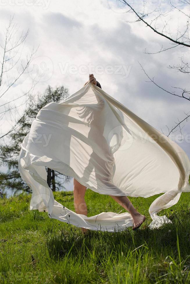 dame spinnen met wit kleding in weide toneel- fotografie foto