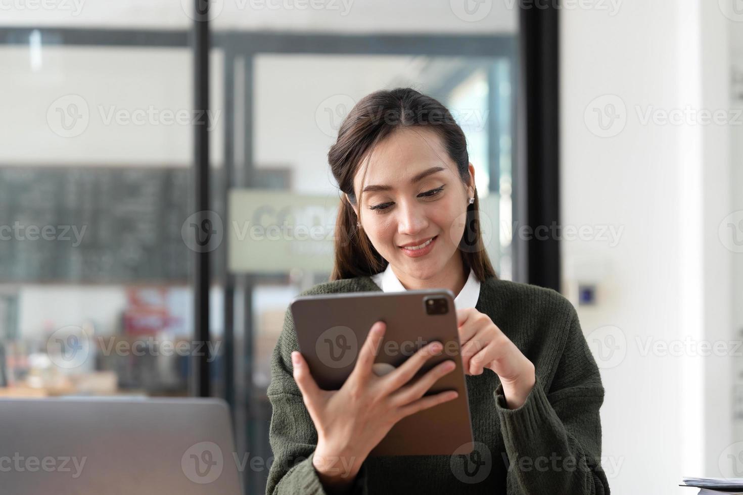 Aziatisch bedrijf vrouw gebruik makend van rekenmachine en laptop voor aan het doen wiskunde financiën Aan een kantoor bureau, belasting, rapport, boekhouding, statistieken, en analytisch Onderzoek concept foto