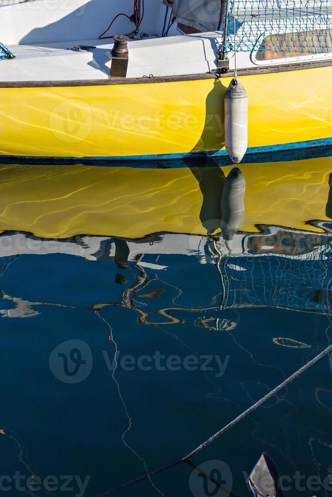 genoegen boot met reflecties in de water in de jachthaven. verticaal afbeelding. foto