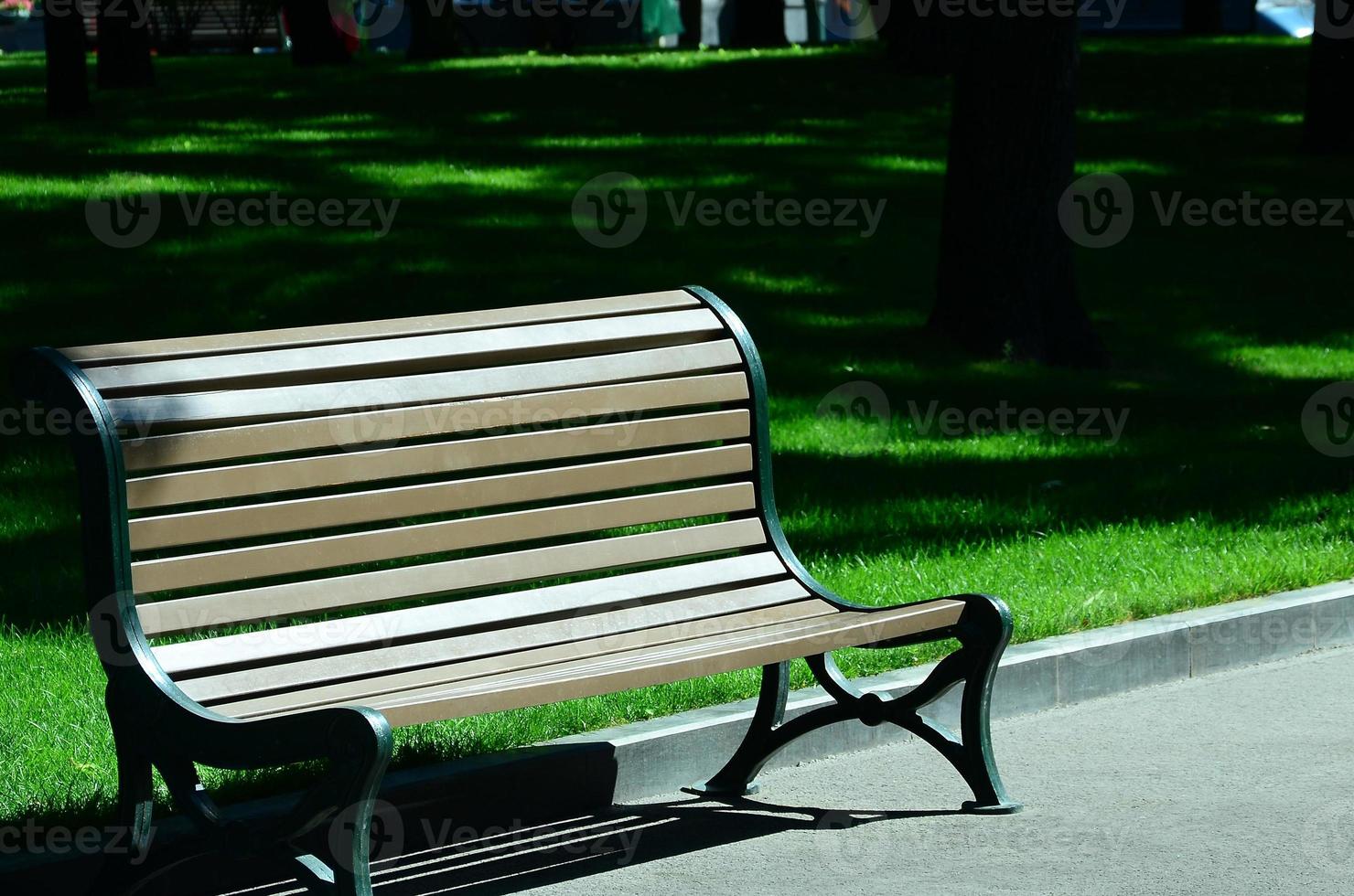 leeg houten bank in de zomer park tegen de groen gras foto