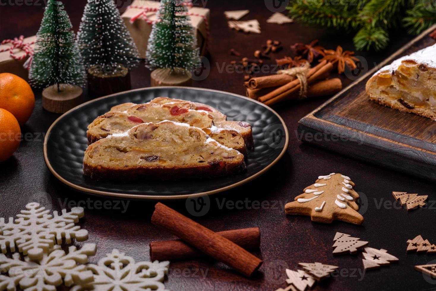 Kerstmis taart stollen met marsepein, bessen en noten Aan een donker beton achtergrond foto