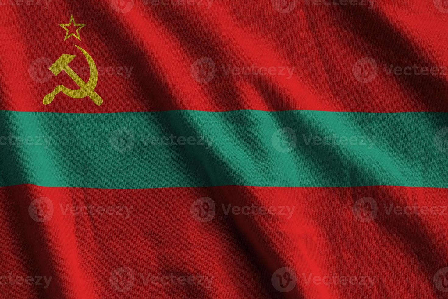 transnistria vlag met groot vouwen golvend dichtbij omhoog onder de studio licht binnenshuis. de officieel symbolen en kleuren in banier foto