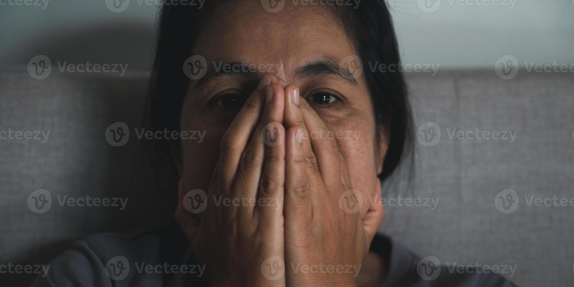 schizofrenie met eenzaam en verdrietig in mentaal Gezondheid depressie concept. depressief vrouw zittend tegen Aan de sofa Bij huis met donker kamer gevoel miserabel. Dames zijn depressief, angstig en ongelukkig. foto