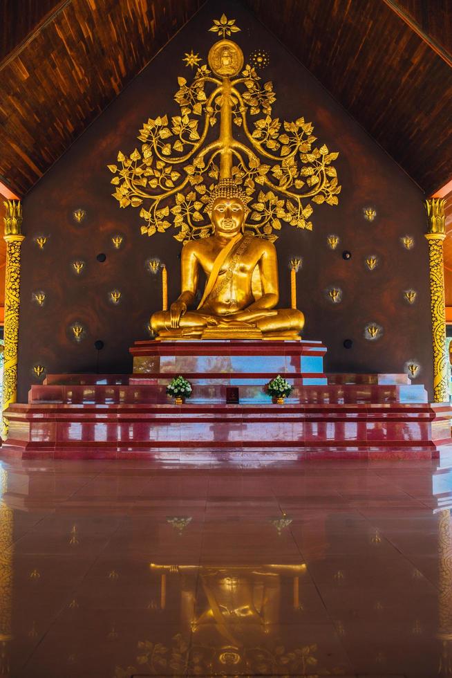 Sirindhorn wararam phu prao tempel van Thailand, een uniek beeld is een gloed van de beeldhouwwerk van de Kalpapruek, welke is gehecht naar de muur achter de kerk. het zullen verschijnen groen gloed in de nacht. foto