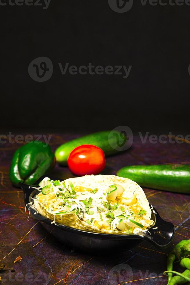 Indisch voedsel bekend net zo masala papad geserveerd net zo beginner voedsel, topping omvat ui, tomaat, groen pepers, vers koriander enz foto