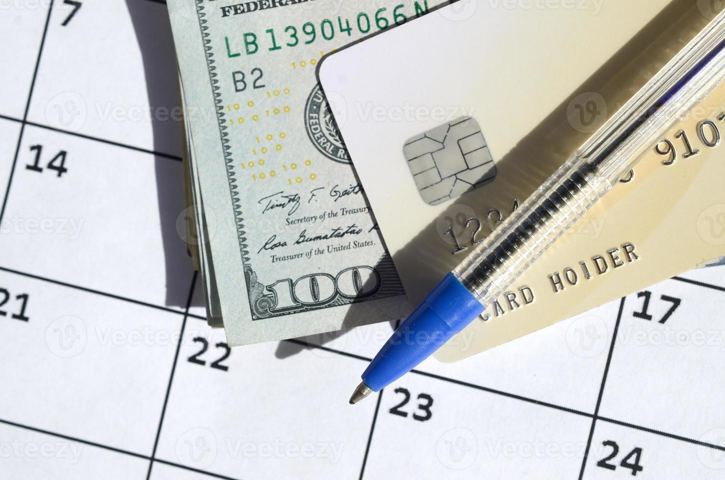 pen en credit kaart Aan veel honderd ons dollar rekeningen Aan kalender bladzijde dichtbij omhoog foto