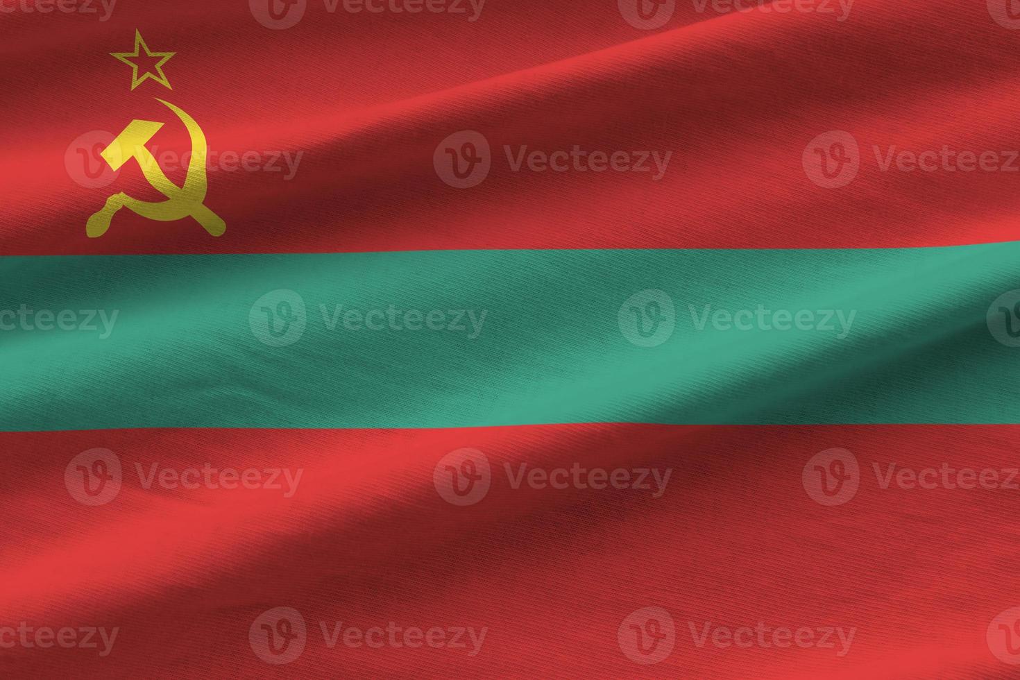 transnistria vlag met groot vouwen golvend dichtbij omhoog onder de studio licht binnenshuis. de officieel symbolen en kleuren in banier foto