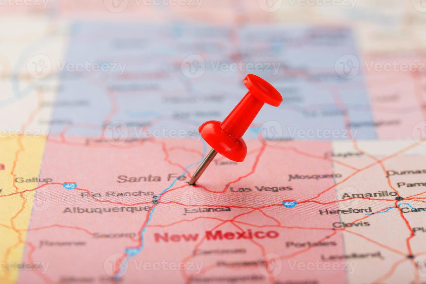 rood klerikaal naald- Aan een kaart van Verenigde Staten van Amerika, nieuw Mexico en de hoofdstad van de kerstman bijv. dichtbij omhoog kaart van nieuw Mexico met rood tack foto