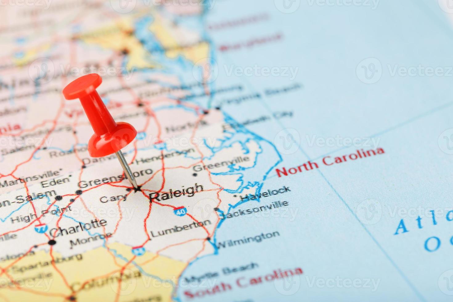 rood klerikaal naald- Aan een kaart van Verenigde Staten van Amerika, zuiden noorden carolina en de hoofdstad raleigh. dichtbij omhoog kaart van zuiden noorden carolina met rood overstag, Verenigde staten kaart pin foto