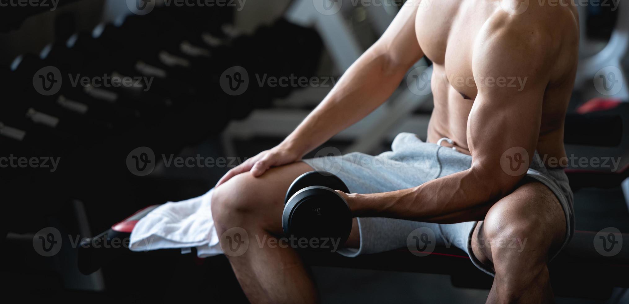 jong Mens training, hijs- met halter naar bouwen spier in geschiktheid Bij Sportschool. foto