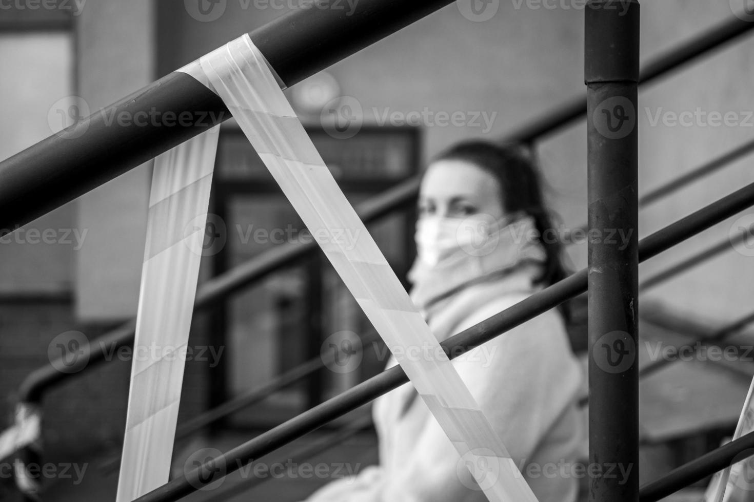 foto van een meisje in een masker. zittend Aan de straat met Gevaar waarschuwing banden.