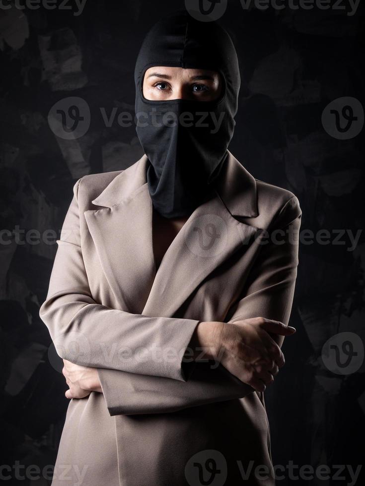 portret van een meisje in een zwart bivakmuts en beige jas. foto