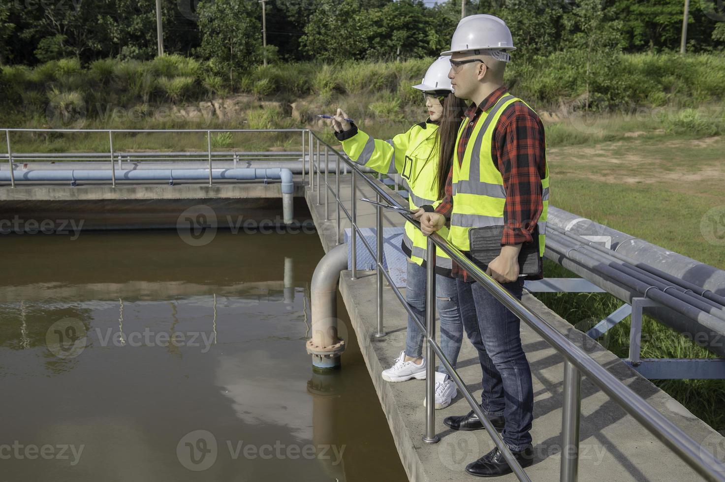 milieu-ingenieurs werken bij afvalwaterzuiveringsinstallaties, watervoorzieningstechniek werken bij waterrecyclinginstallaties voor hergebruik, technici en ingenieurs bespreken samenwerking. foto