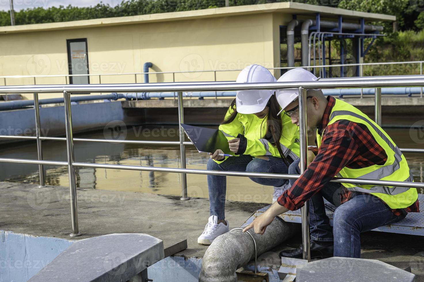 milieu-ingenieurs werken bij afvalwaterzuiveringsinstallaties, watervoorzieningstechniek werken bij waterrecyclinginstallaties voor hergebruik, technici en ingenieurs bespreken samenwerking. foto