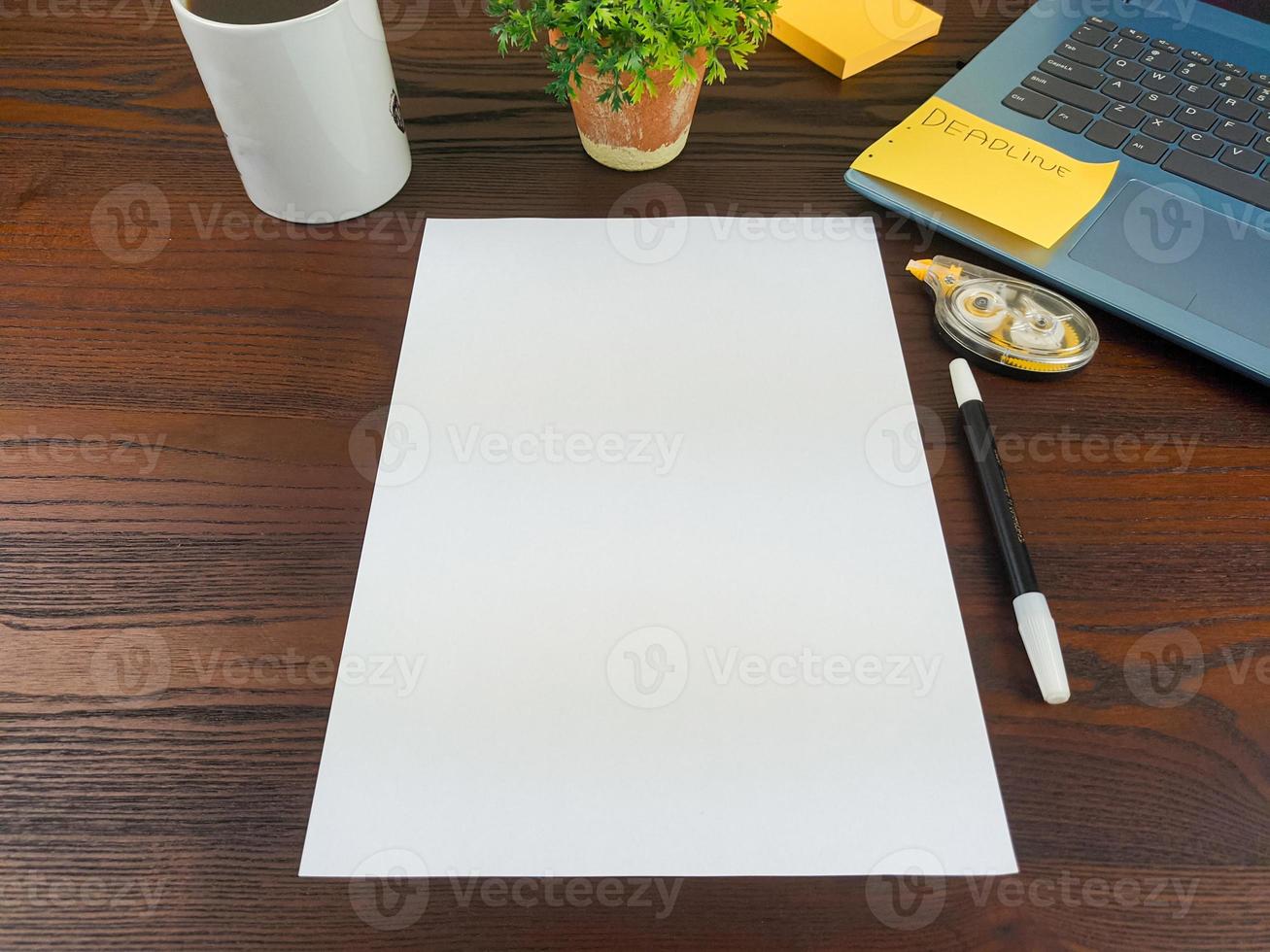 vlak leggen, bespotten omhoog papier. werkruimte in de achtergrond van de kantoor bureau van de top visie. met blanco wit papier, laptops, kantoor benodigdheden, potloden, groen bladeren, en koffie cups foto