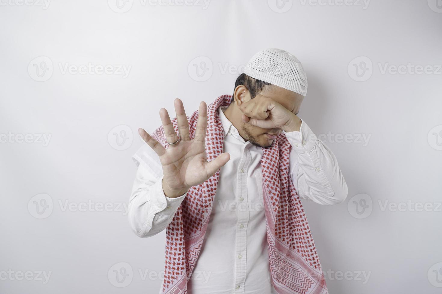 jong Aziatisch moslim Mens geïsoleerd Aan wit achtergrond, looks depressief, gezicht gedekt door vingers bang en zenuwachtig. foto