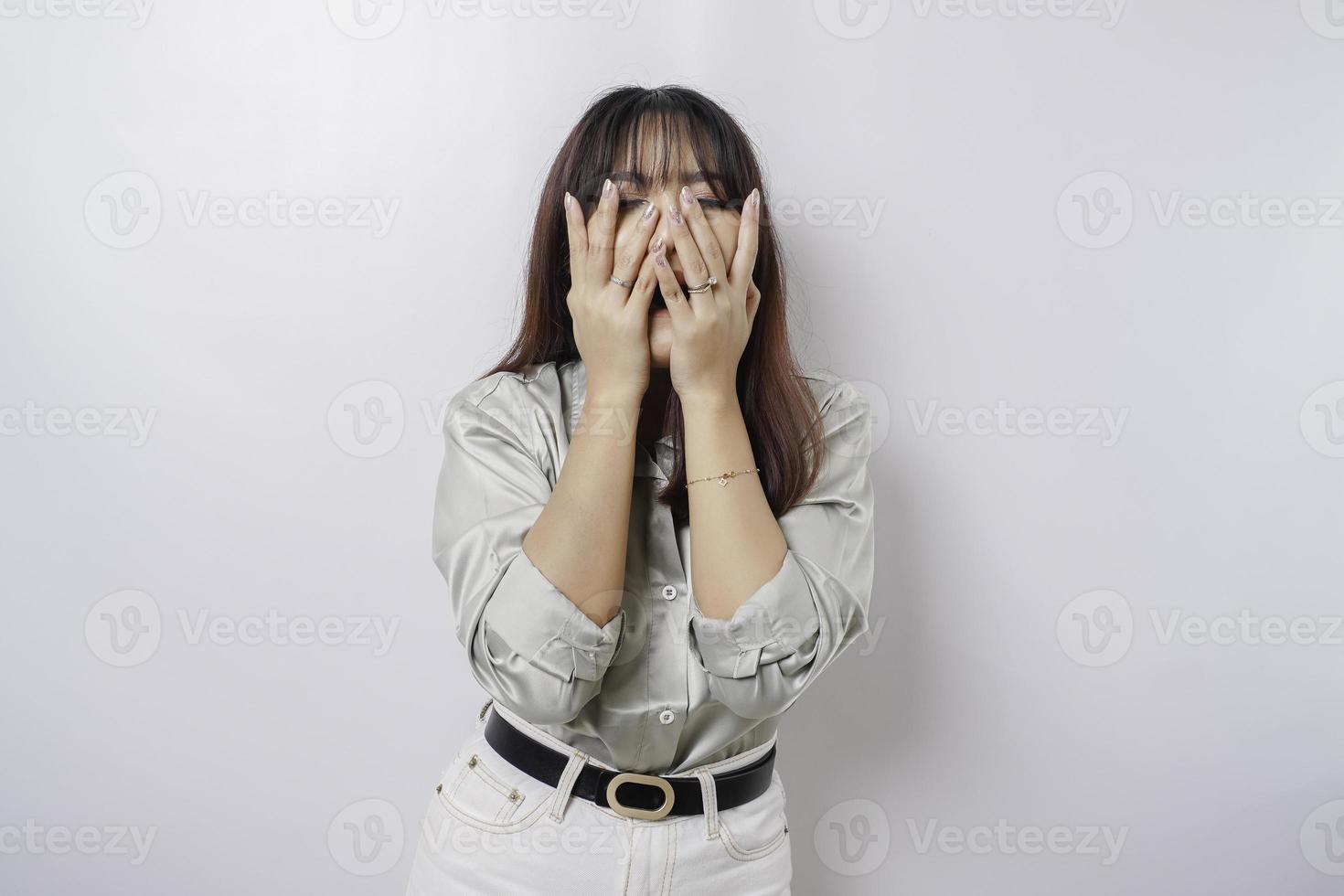 een portret van een Aziatisch vrouw vervelend een salie groen overhemd geïsoleerd door wit achtergrond looks depressief foto