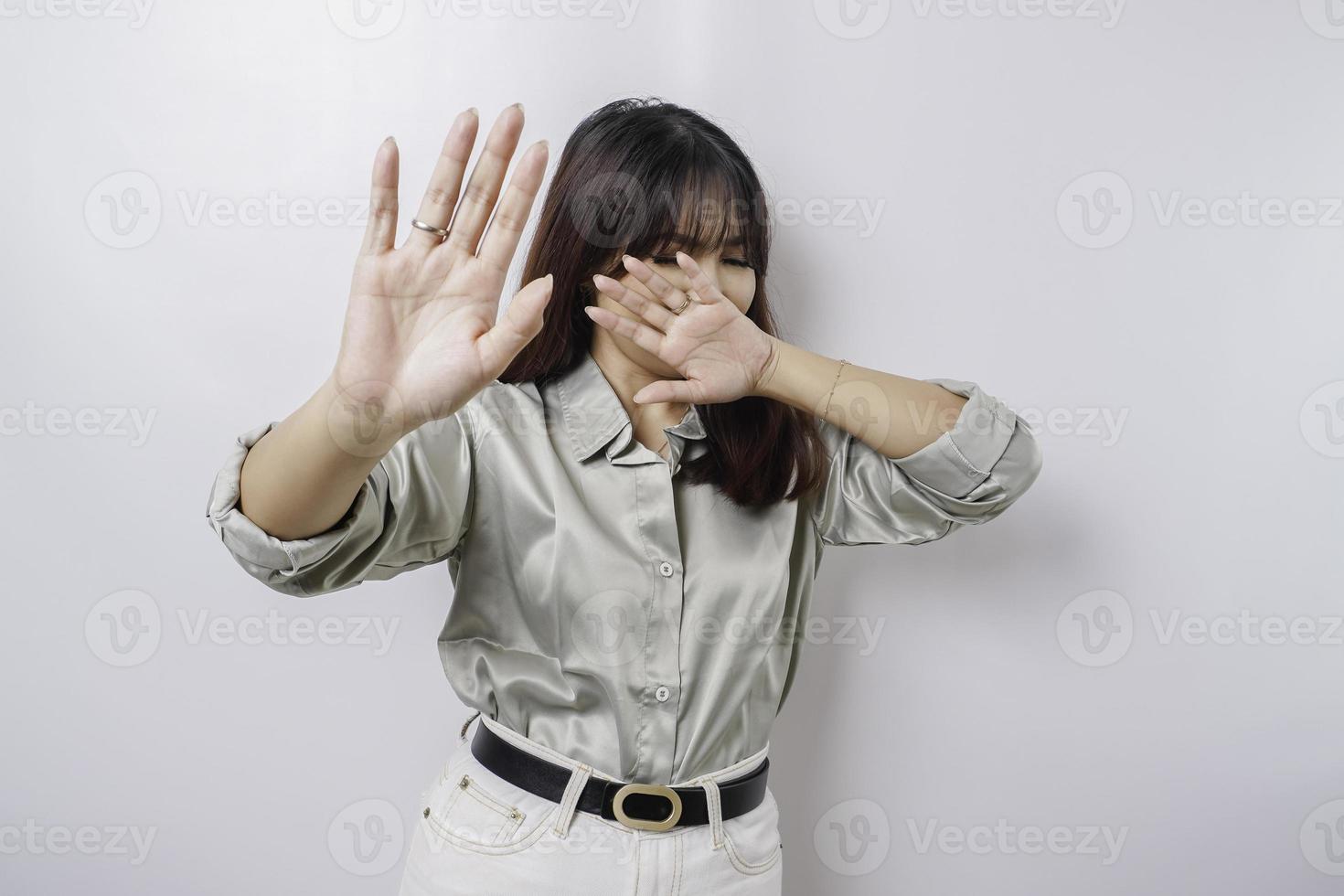 jong Aziatisch vrouw geïsoleerd Aan wit achtergrond, looks depressief, gezicht gedekt door vingers bang en zenuwachtig. foto