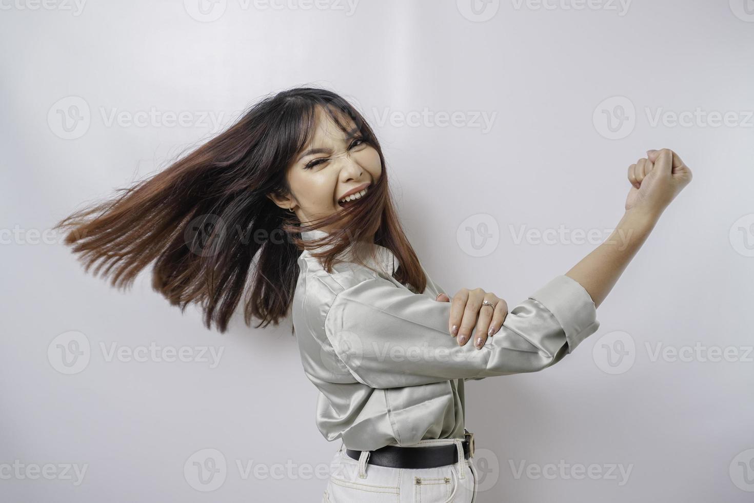opgewonden Aziatisch vrouw vervelend een salie groen overhemd tonen sterk gebaar door hijs- haar armen en spieren glimlachen trots foto