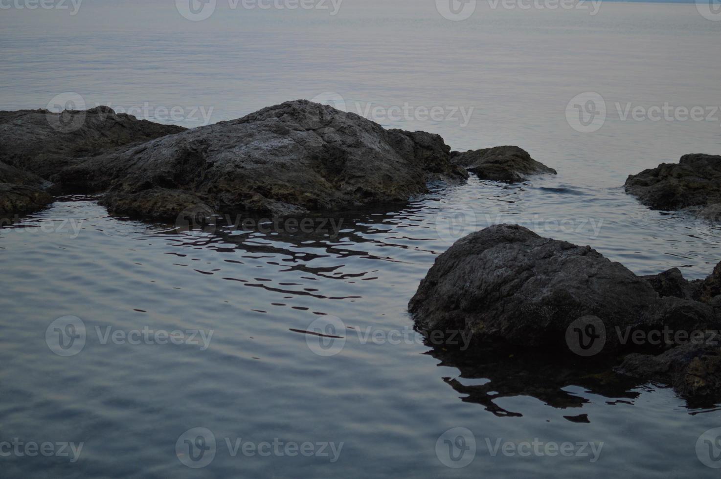 rotsen Bij de strand, kalmte water foto