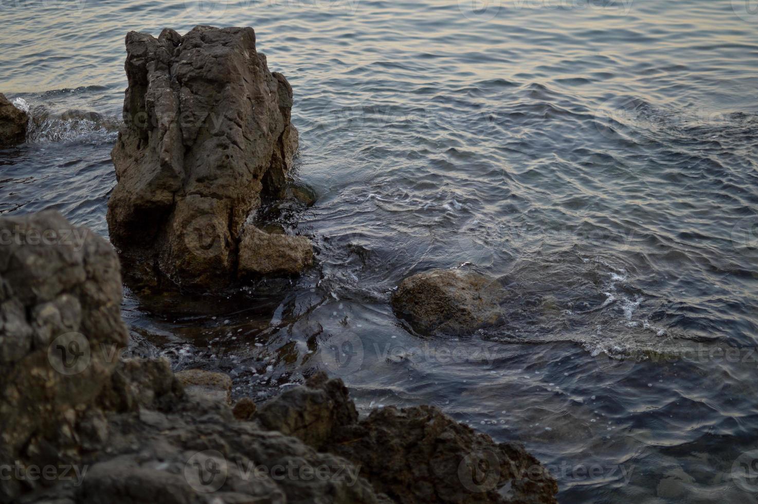 rotsen Bij de strand, kalmte water foto
