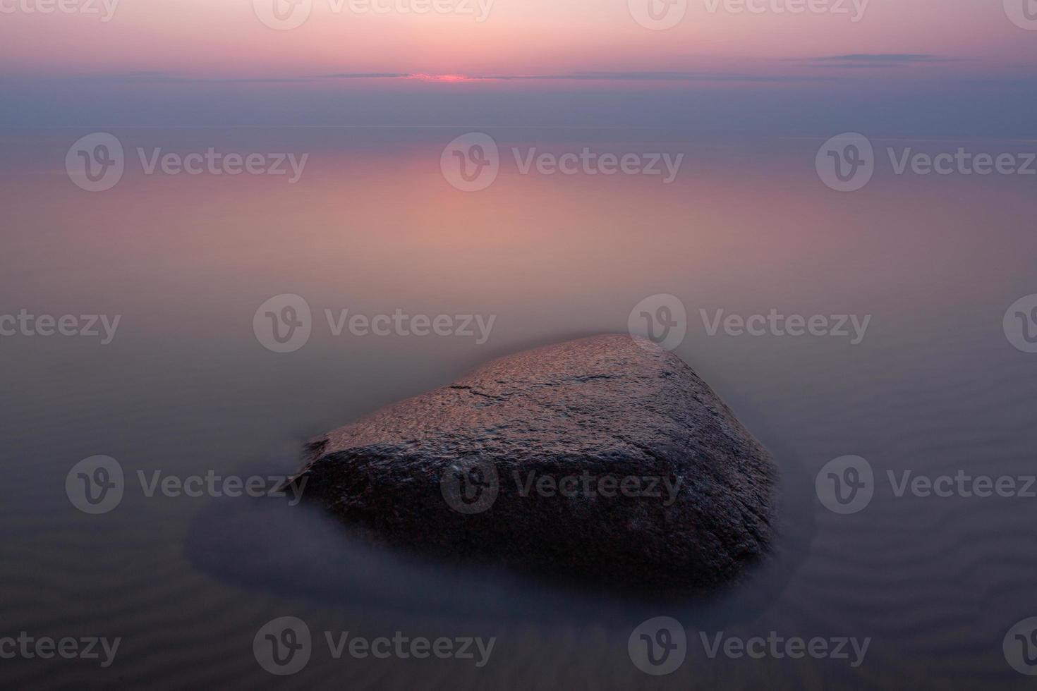stenen Aan de kust van de Baltisch zee Bij zonsondergang foto