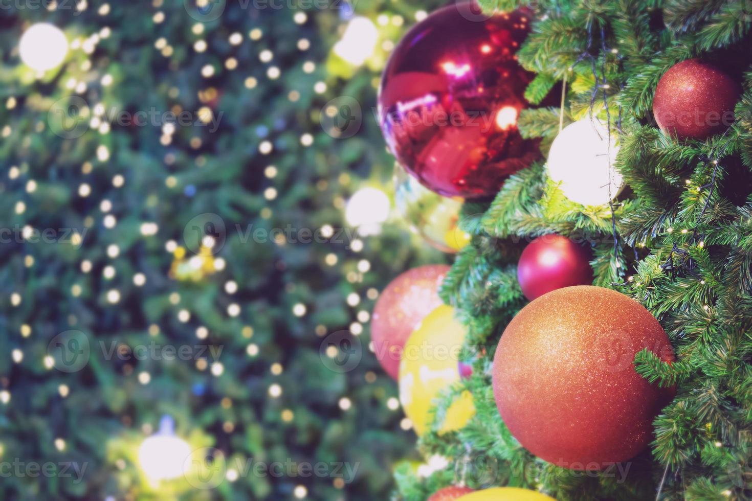 close-up van snuisterij kleurrijke variëteit opknoping van een versierde kerstboom op wazig van lichten met versierde boom, sprankelende en bokeh achtergrond. kopieer ruimte voor uw tekst. kerstboomversiering foto
