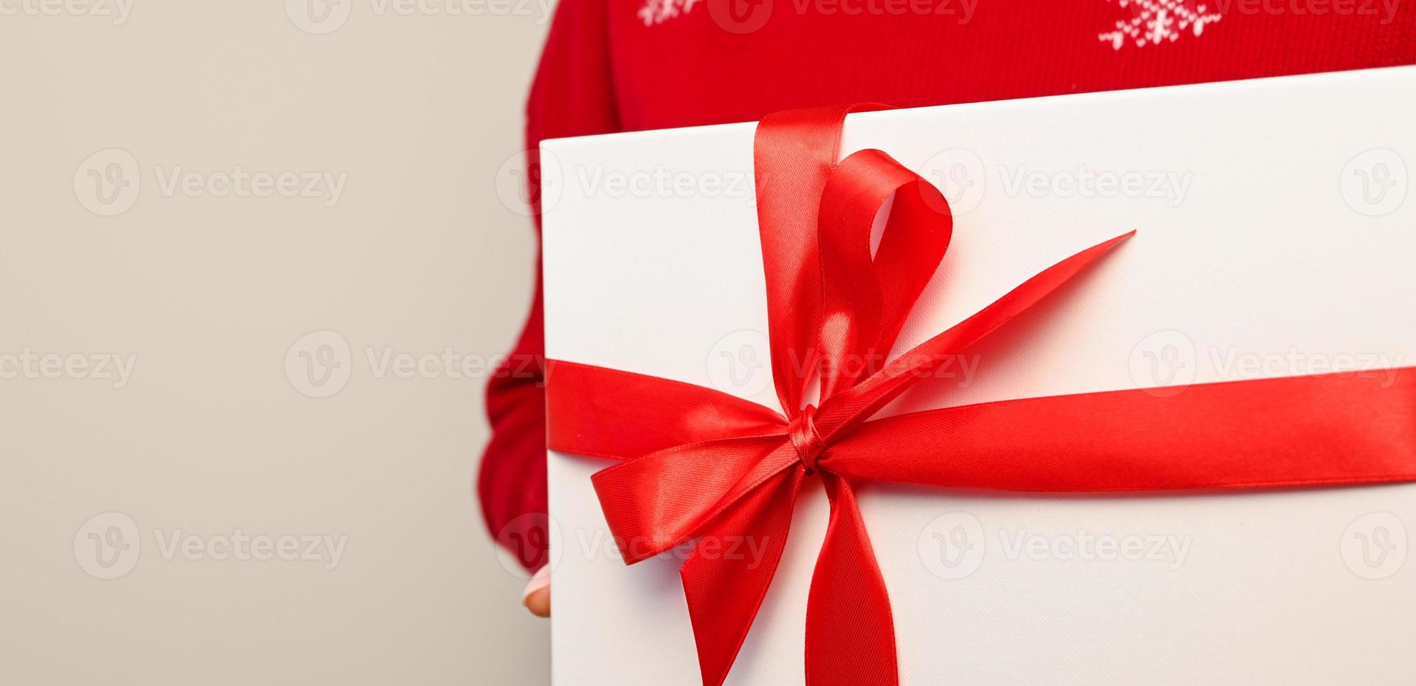Kerstmis banier van een vrouw Holding groot geschenk met rood bow.copyspace.minimalistisch foto