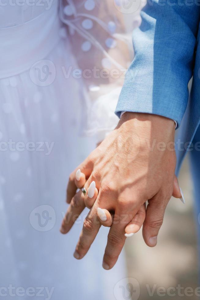 de bruid en bruidegom houden teder de handen vast tussen hen liefde en relaties foto