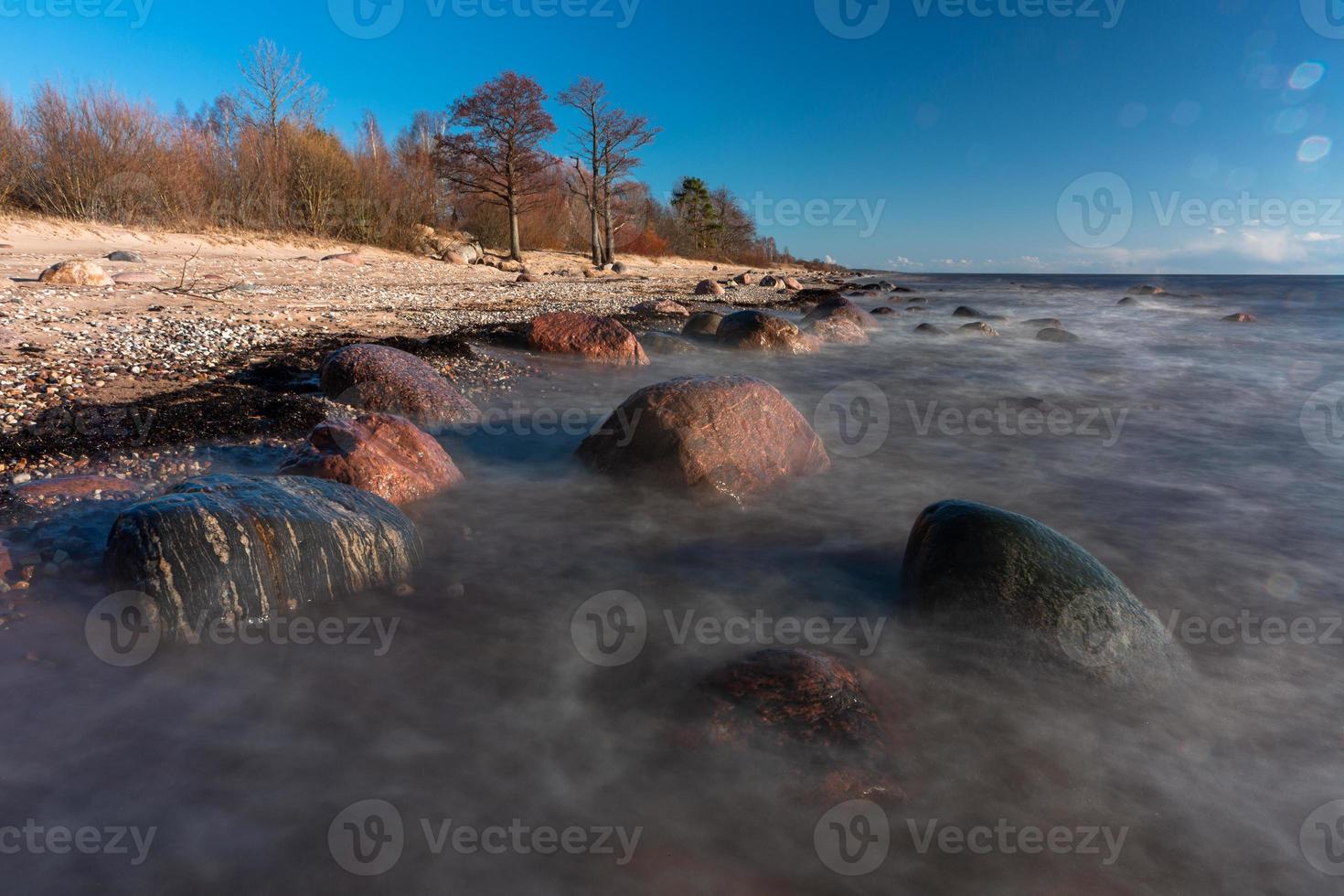 stenen Aan de kust van de Baltisch zee Bij zonsondergang foto