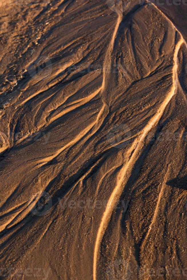 Baltisch zee kust met steentjes en ijs Bij zonsondergang foto