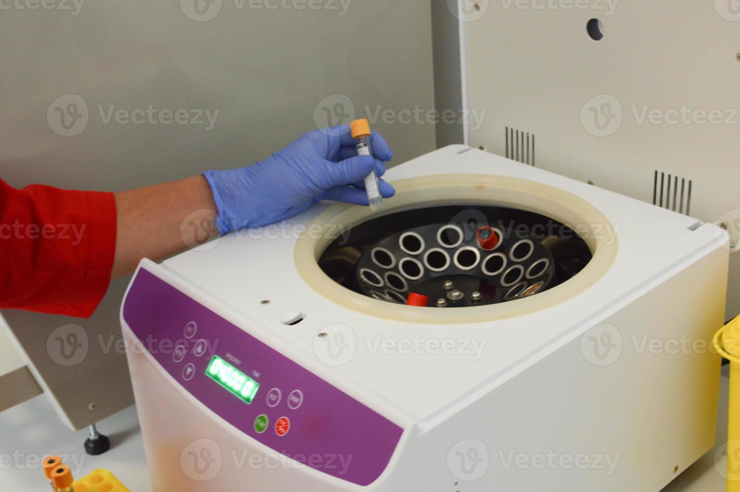 buizen zijn geplaatst in de analyzer voor centrifugeren. prestatie van laboratorium testen, examen van veneus bloed in speciaal apparatuur. dokter zet een test buis in een centrifuge foto