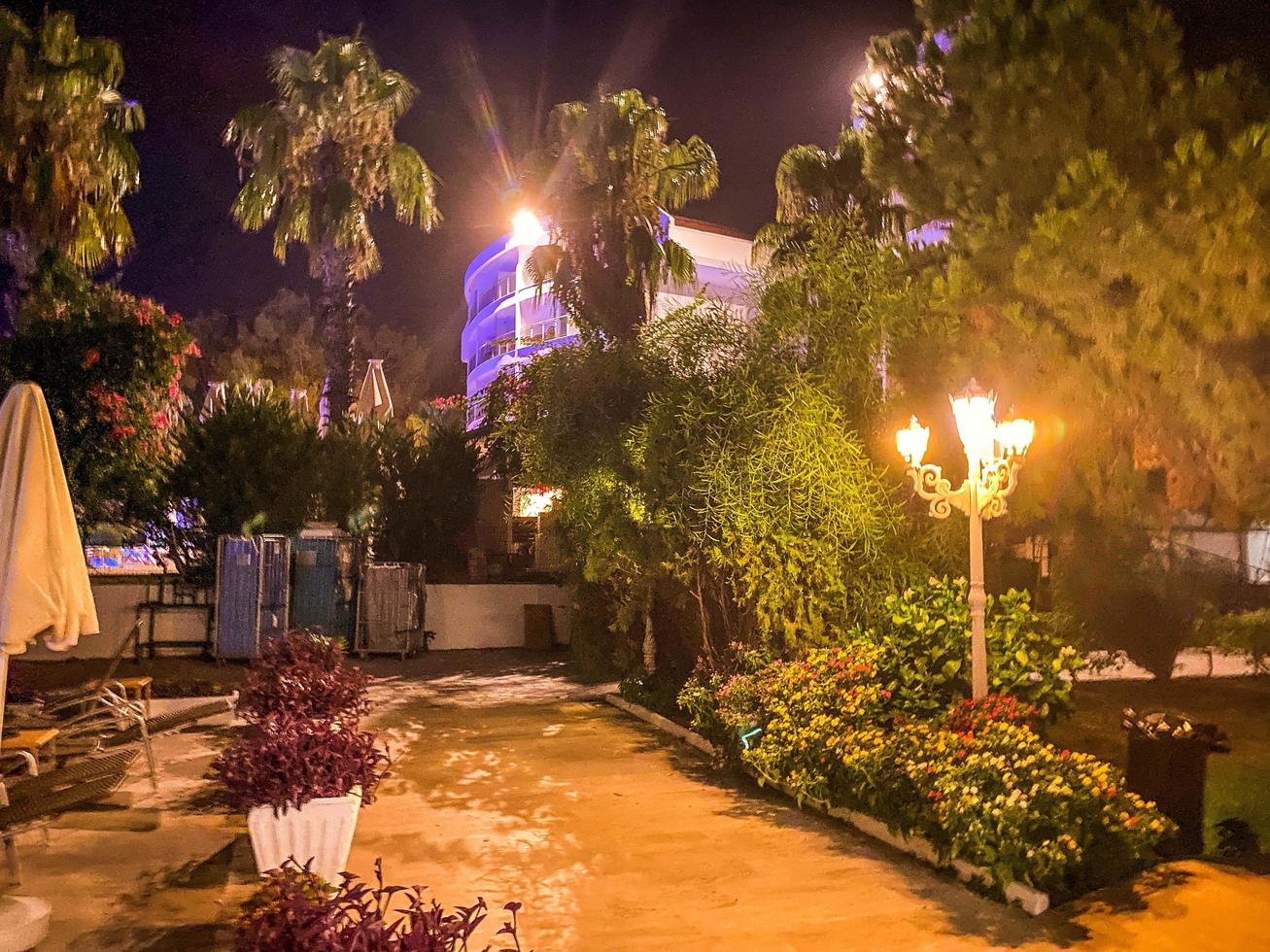 hotel gebied voor toeristen in een heet land. hotel met groen bomen en gras. inbegrepen lichten dat creëren een schattig geel licht foto