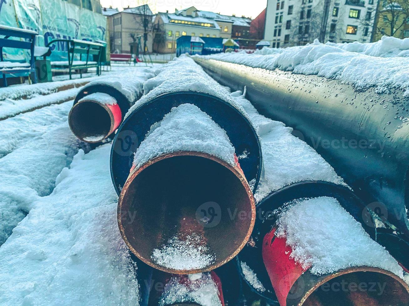 lang, zwart, versmallen pijpen voor houdende loodgieter communicatie. metaal pijpen zijn gedekt met een laag van sneeuw. riool beschikbaarheid. vernieuwing werk in een woon- Oppervlakte foto